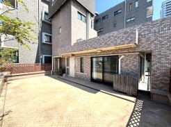 青空の下、広々とした敷地は、穏やかな日差しを浴びて心地よい開放感に包まれています。レンガ調の外壁が落ち着いた雰囲気を醸し出し、ゆとりのある暮らしを予感させます
