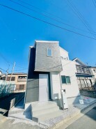 澄んだ空の下、白と黒のコントラストが印象的な住まい