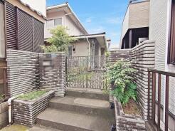 重厚感のあるタイル張りの門柱と緑豊かなアプローチが落ち着いた佇まいを演出します
