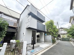モノトーンの配色が洗練された印象を与える、周囲の街並みと調和したモダンな佇まいの外観です。