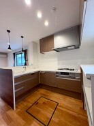 キッチンはL字型を採用。食洗器付きで落ち着いたブラウンカラー。