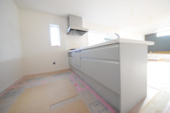 リビングにいる家族の顔が見渡せるカウンターキッチン。お料理もより一層おいしく、楽しく。食器棚を背面に設置しても十分な広さを確保しています。

時短に活躍する食器洗浄機や一杯の水も楽しめる浄水器があるシステムキッチン。
