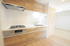 壁付のキッチンは上部に収納が作りやすいのがメリット。空間を有効活用したすっきりとしたデザイン。
