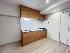 壁付のキッチンは上部に収納が作りやすいのがメリット。空間を有効活用したすっきりとしたデザイン。
