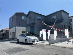 青空の下、モダンな外観と彩り豊かなガーランドが調和する住まい