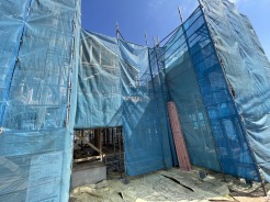 青いシートに包まれた、未来への期待が膨らむ建設現場