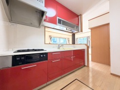 鮮やかな赤のキッチンが、空間に活気と彩りを与えています