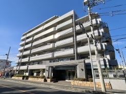 青空の下、穏やかな光が注ぐ、落ち着いた佇まいの住まい