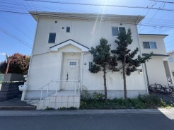 玄関前の緑が、穏やかな佇まいを一層引き立てる住まい