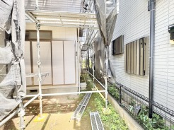 工事中の足場とシートに覆われ、静かな時間が流れる外構