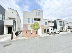 レンガ調のデザインと柔らかな植栽が調和した、街並みに溶け込む親しみやすい佇まいの住まいです。