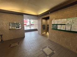 落ち着いた色調のタイルが整然と並び、静けさと安心感が漂う端正なエントランス空間です。