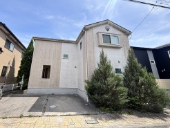 青空に映える優しい色合いの外観が、穏やかな日常を予感させる落ち着いた佇まいです。