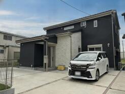 洗練された黒の外壁と温かみのある石目調のアクセントが調和する、モダンで落ち着いた佇まいの住まいです。