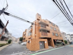 温かみのあるタイル貼りの外観が街並みに調和し、穏やかな日常を予感させる佇まい。