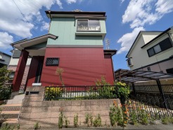 青空に映える個性的な色使いの外観が、街並みの中で穏やかな存在感を放っています。