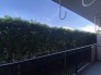鮮やかな緑の植栽が視界に広がり、空の青さと相まって穏やかな余白を感じさせる開放的な空間です。