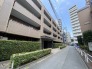 植栽の緑と落ち着いた色調の外観が調和し、街並みに穏やかな風景を創り出しています。