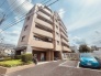 落ち着いた色合いの外観が青空に映える街並みに調和する佇まいです。
