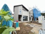 落ち着いた色合いの外観が青空に映えるすっきりとした佇まいの住まい
