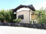 緑豊かな植栽と石積みの塀が、穏やかな暮らしを育む住まい。