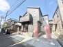 青空の下、洗練された佇まいが街並みに調和する住まい