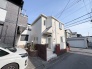 空と街並みに調和する、柔らかな色合いの邸宅。