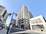 広がる青空の下、街並みに調和する洗練された外観