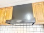 木目の温かみとモダンなレンジフードが調和する、落ち着いたキッチン空間。