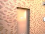 レンガ調の外壁に、温かな光を映す扉のある空間。