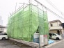 緑のシートに包まれ、未来への期待を抱かせる建築現場