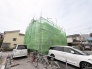 緑のシートが印象的な、穏やかな街並みに佇む建物