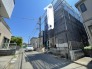 閑静な住宅街の中に佇み、これから新しい暮らしが紡がれていく静かな街並みの風景です。