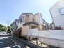 青空のもと、落ち着いた色合いの外観が周辺の静かな環境と調和し、穏やかな暮らしを予感させます。