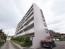 街並みに静かに佇む、端正なフォルムが印象的な集合住宅の外観です。