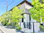 青々とした木々に囲まれ、街並みと穏やかに調和する落ち着いた佇まいの外観です。