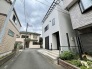周囲の落ち着いた街並みに調和する、洗練された白の外観が印象的な住まいです。