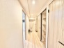 木目の美しい建具と柔らかな色合いが調和する、すっきりと洗練された廊下空間。