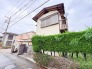 緑の生垣が季節の移ろいを感じさせ、街並みに穏やかに溶け込む趣のある外観です。