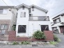 落ち着いたレンガ調の設えが印象的で、街並みに穏やかに溶け込む住まいの外観です。