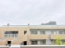 穏やかな空が広がり周辺の環境と調和した落ち着いた佇まいを見せる外観です