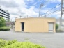 青い空の下に落ち着いた佇まいを見せる、シンプルで機能的な外観の建物です。