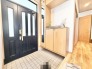 洗練されたダークトーンの建具と温かみのある木目が調和する、落ち着いた佇まいのエントランス空間です。