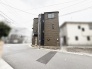 洗練されたブラウンの外壁が街並みに調和する、落ち着いた佇まいの邸宅です。