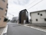 落ち着いた色合いの外観が周囲の街並みに調和し、穏やかな暮らしの風景を描き出します。