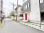 洗練されたモノトーンの外観に鮮やかな赤色のドアが映える個性的な佇まい