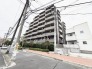 落ち着いた色合いの外観が周囲の街並みに調和する、洗練された佇まいを魅せる建物。