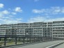 青空が広がる開放的な景色に調和する、落ち着いた佇まいを見せる外観デザインです。