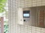 落ち着いた色合いのタイル壁に囲まれた、安心感を高めるスマートなエントランス仕様。