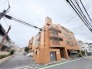 温かみのあるタイル貼りの外観が街並みに調和し、穏やかな日常を予感させる佇まい。